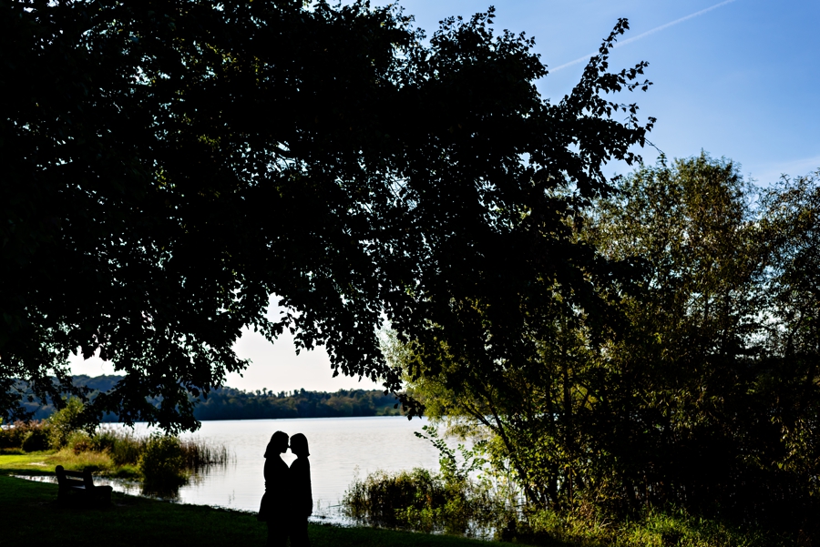 A silhouette of a lesbian couple in front of a lake at Marsh Creek State Park.
